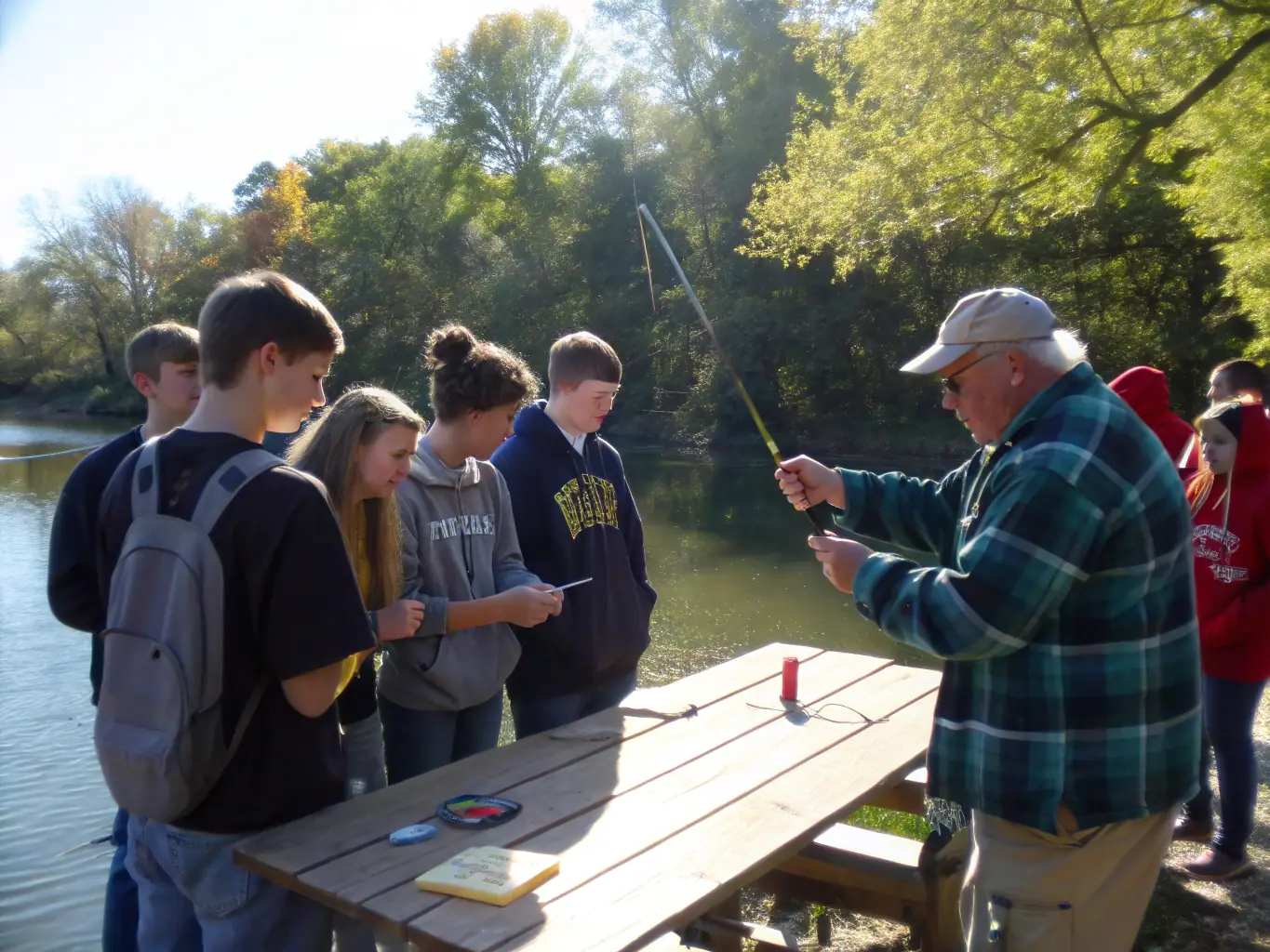 A photograph of AAPPMA LE LEGUER members conducting a workshop on responsible fishing practices for local anglers, with educational materials and fishing gear displayed.